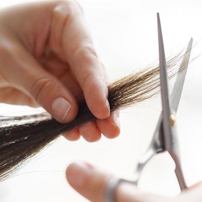 Cutting hair with scissors to make someone look younger