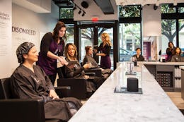 Women sitting at Madison Reed hair color bar getting hair colored