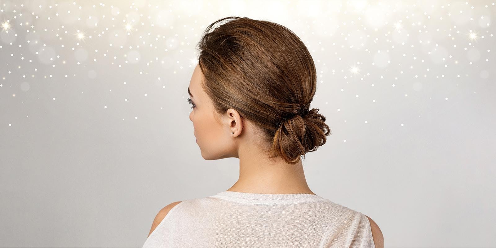 Woman with brown hair and low bun updo